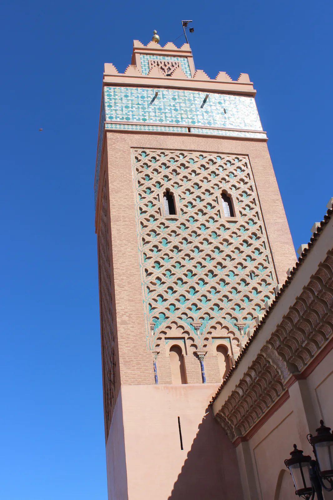 Tiled minaret of the El Mansour mosque in Marrakech against a blue sky